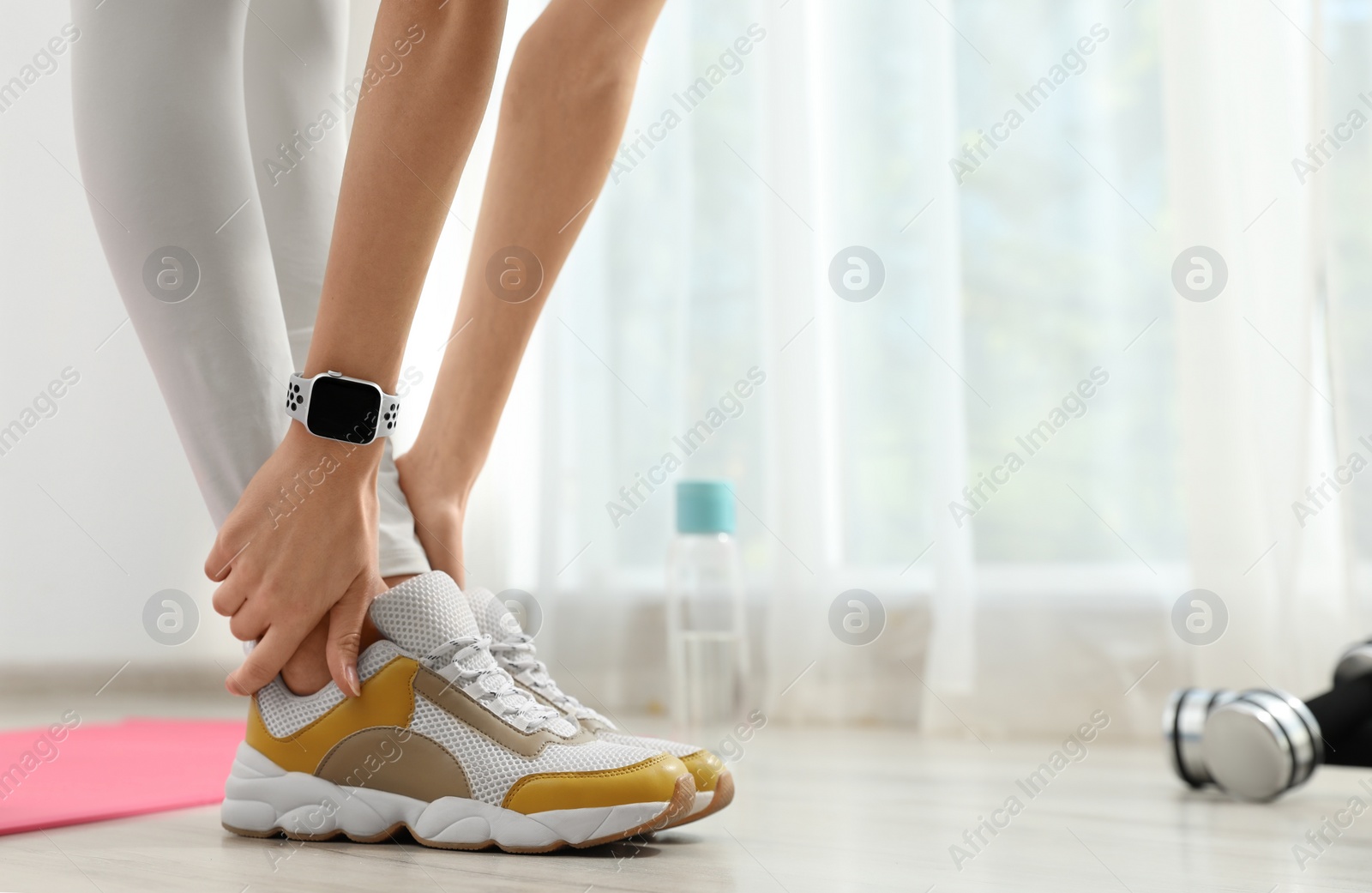 Photo of Young woman wearing smart watch during training indoors, closeup. Space for text