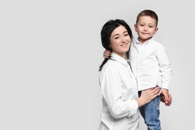 Beautiful mother with little son on white background. Space for text