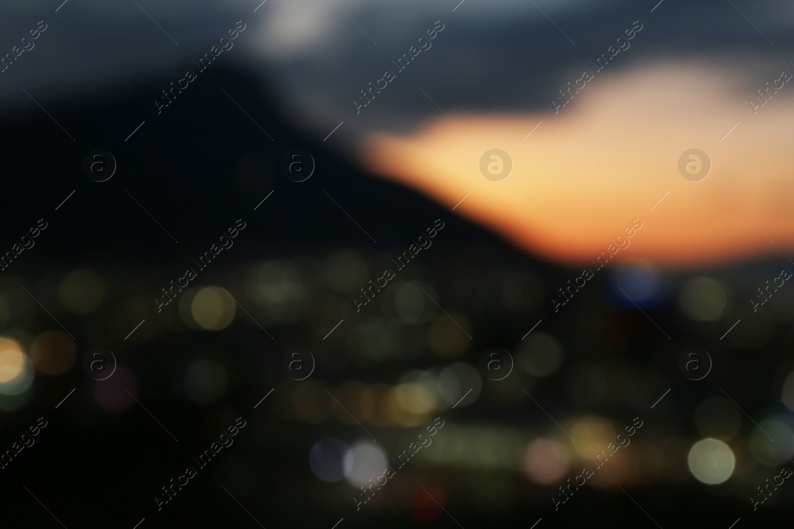 Photo of Blurred view of beautiful sunset with mountains in city, bokeh effect