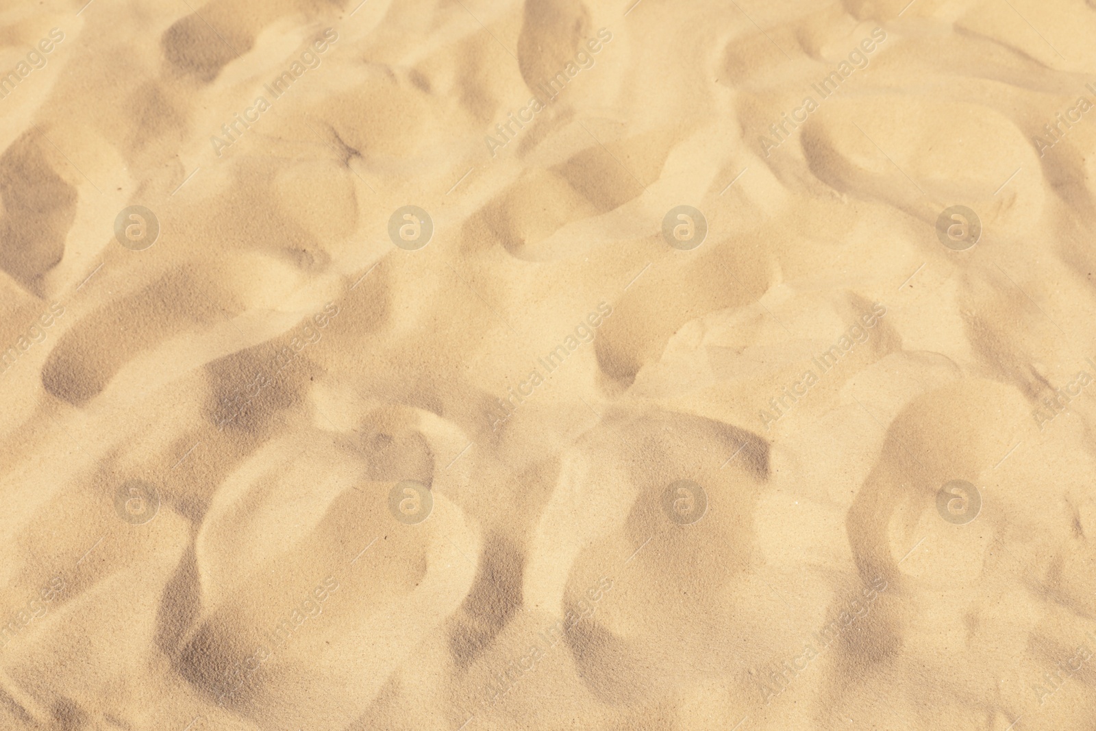 Photo of Golden beach sand on sunny day as background