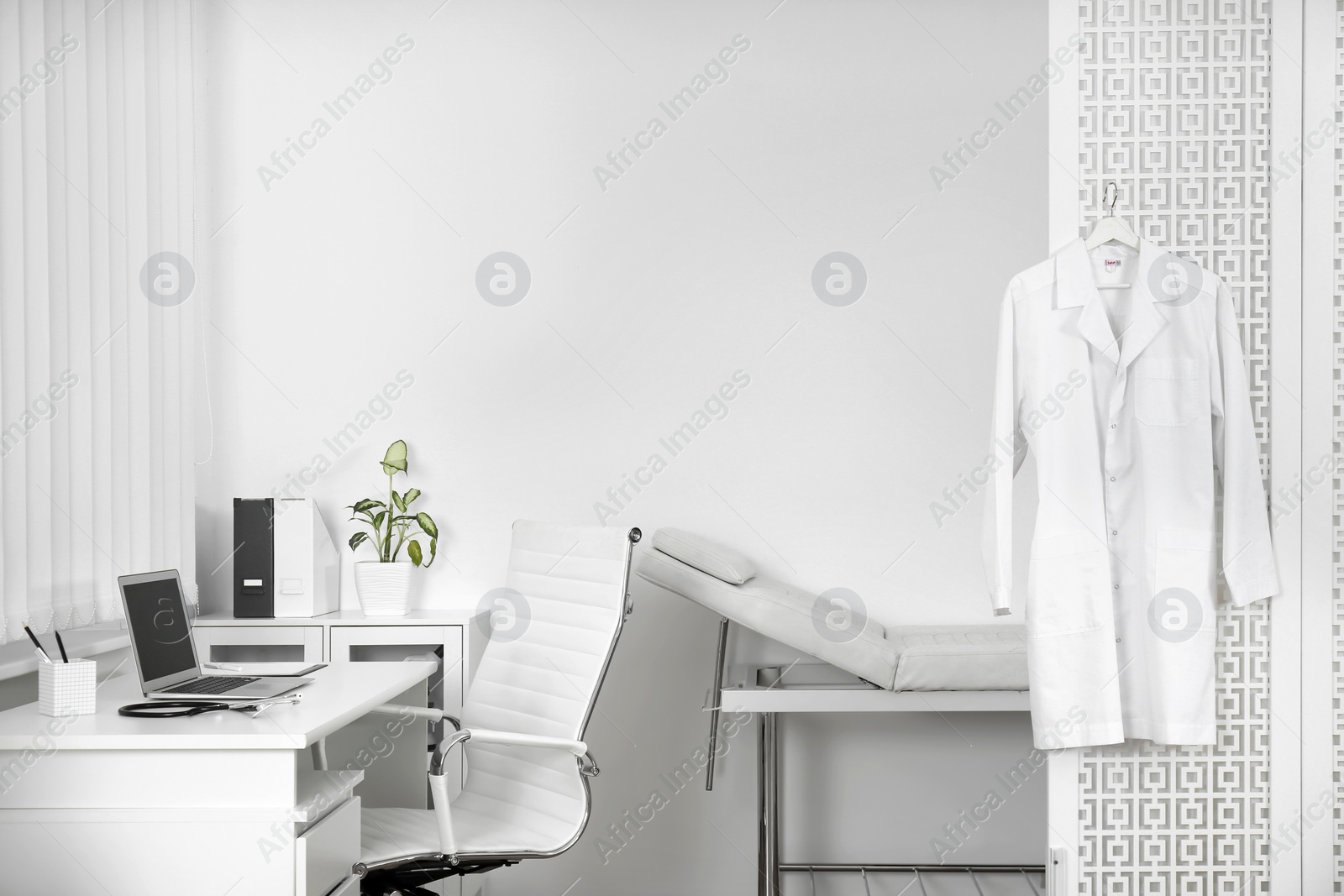 Photo of Doctor's office interior with desk and examination couch