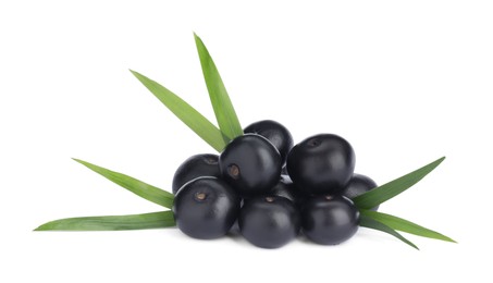 Photo of Pile of fresh ripe acai berries and green leaves on white background