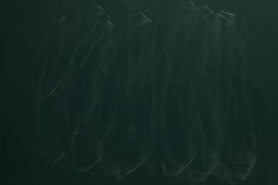 Photo of Chalk rubbed out on green chalkboard as background, closeup. Space for text