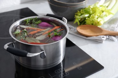 Pot of delicious vegetable bouillon on stove in kitchen