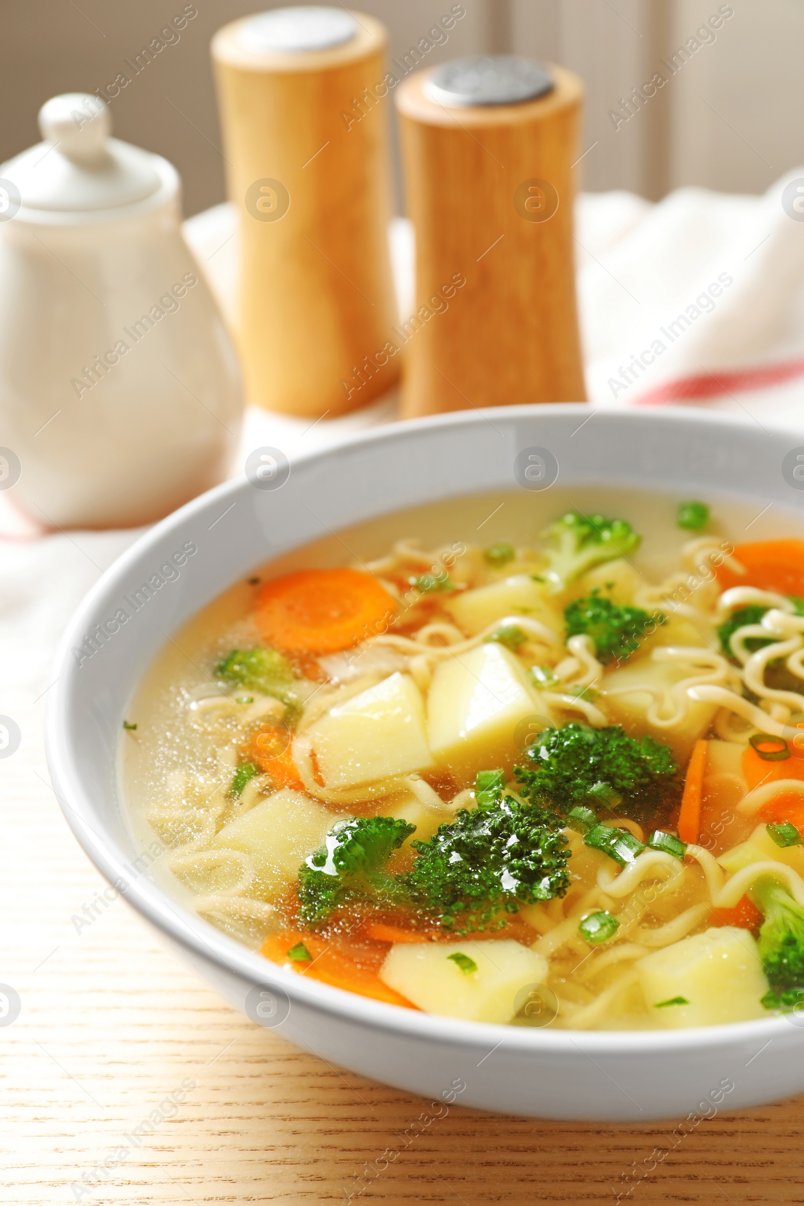 Photo of Bowl of fresh homemade vegetable soup on wooden table