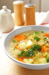 Bowl of fresh homemade vegetable soup on wooden table