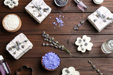 Flat lay composition with hand made soap bars and lavender flowers on wooden table