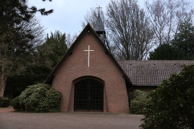 Photo of Beautiful brick church and green trees outdoors