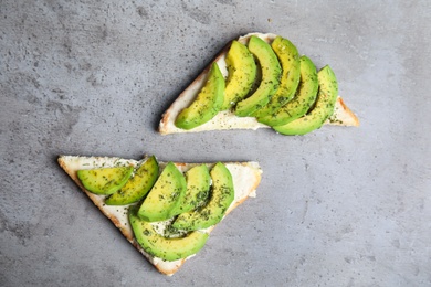 Tasty toasts with avocado on light grey table, flat lay