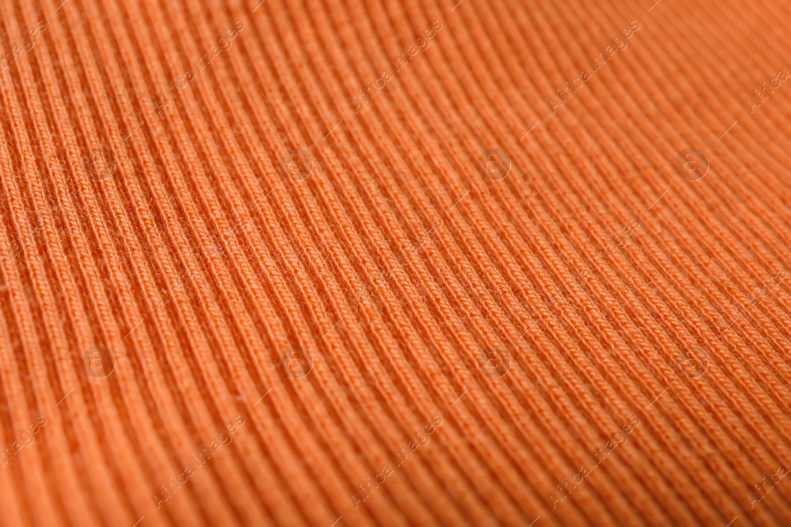 Photo of Texture of knitted orange fabric as background, closeup