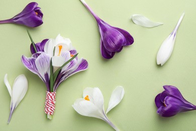 Beautiful crocus flowers on beige background, flat lay