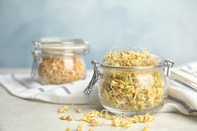 Jar of sprouted green buckwheat on light table, closeup