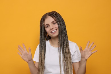 Photo of Young woman giving high five with both hands on yellow background