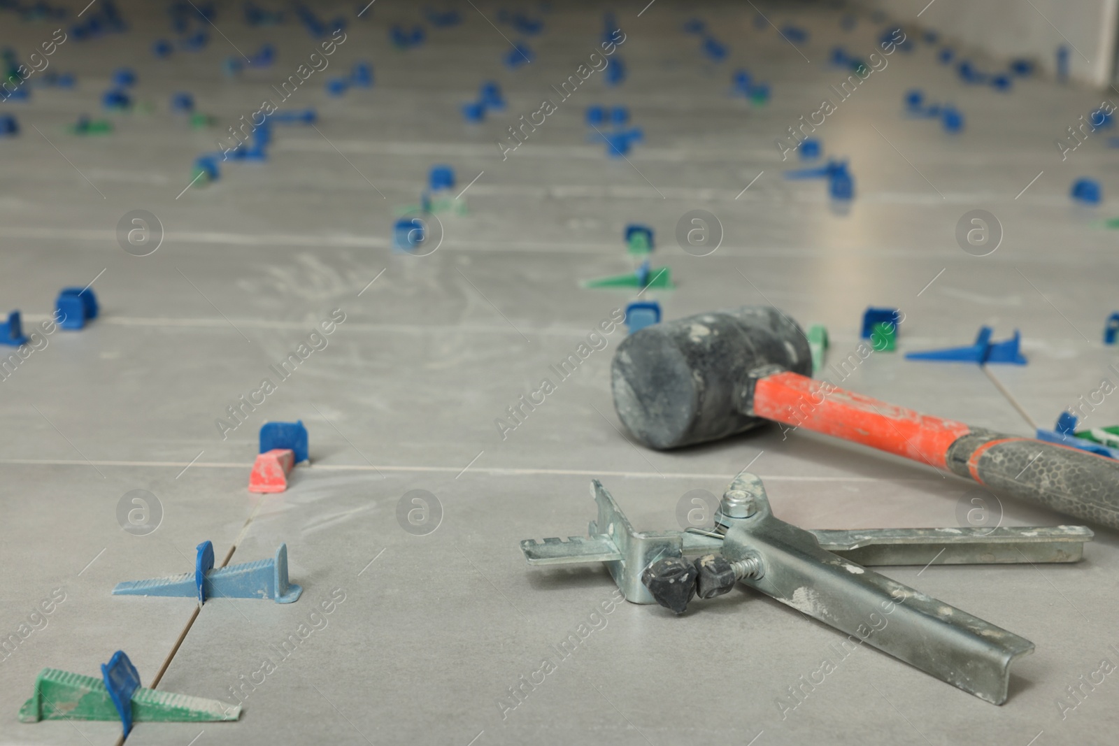 Photo of Beautiful tiles with colorful wedges and professional equipment on floor