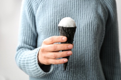 Photo of Woman with snow ice cream cone on light background, closeup