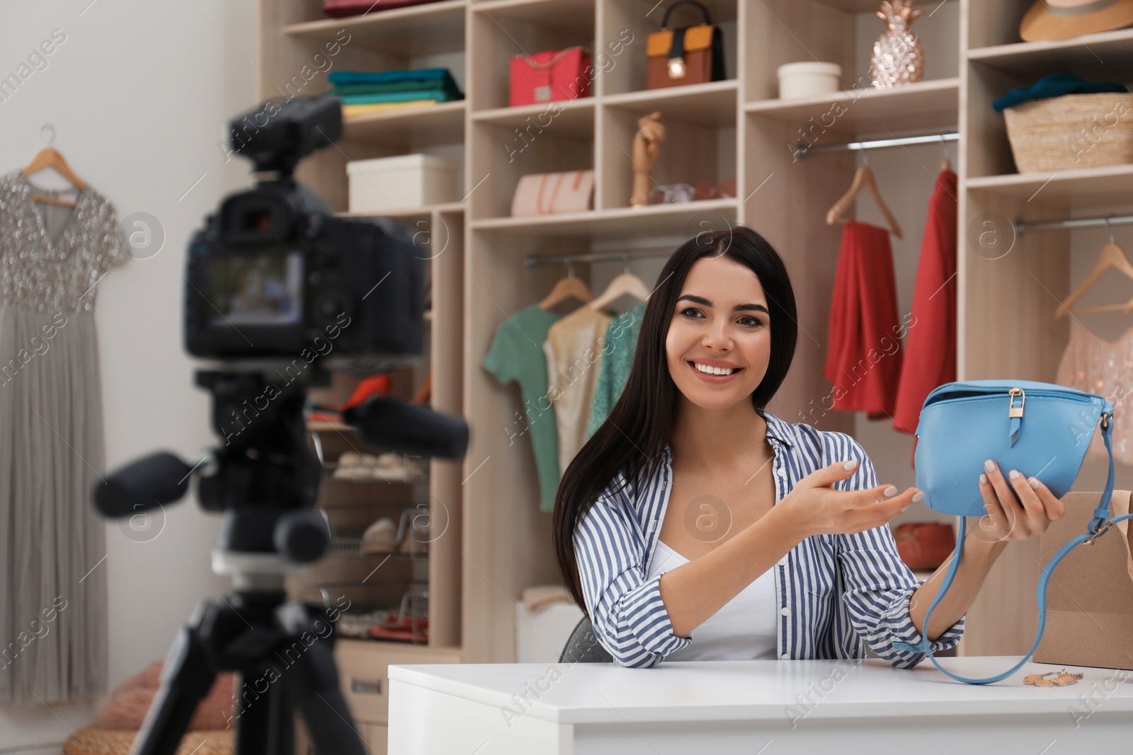 Photo of Fashion blogger recording new video at table indoors