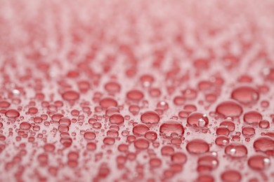 Water drops on red background, closeup view