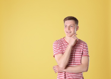 Photo of Portrait of teenage boy on yellow background. Space for text
