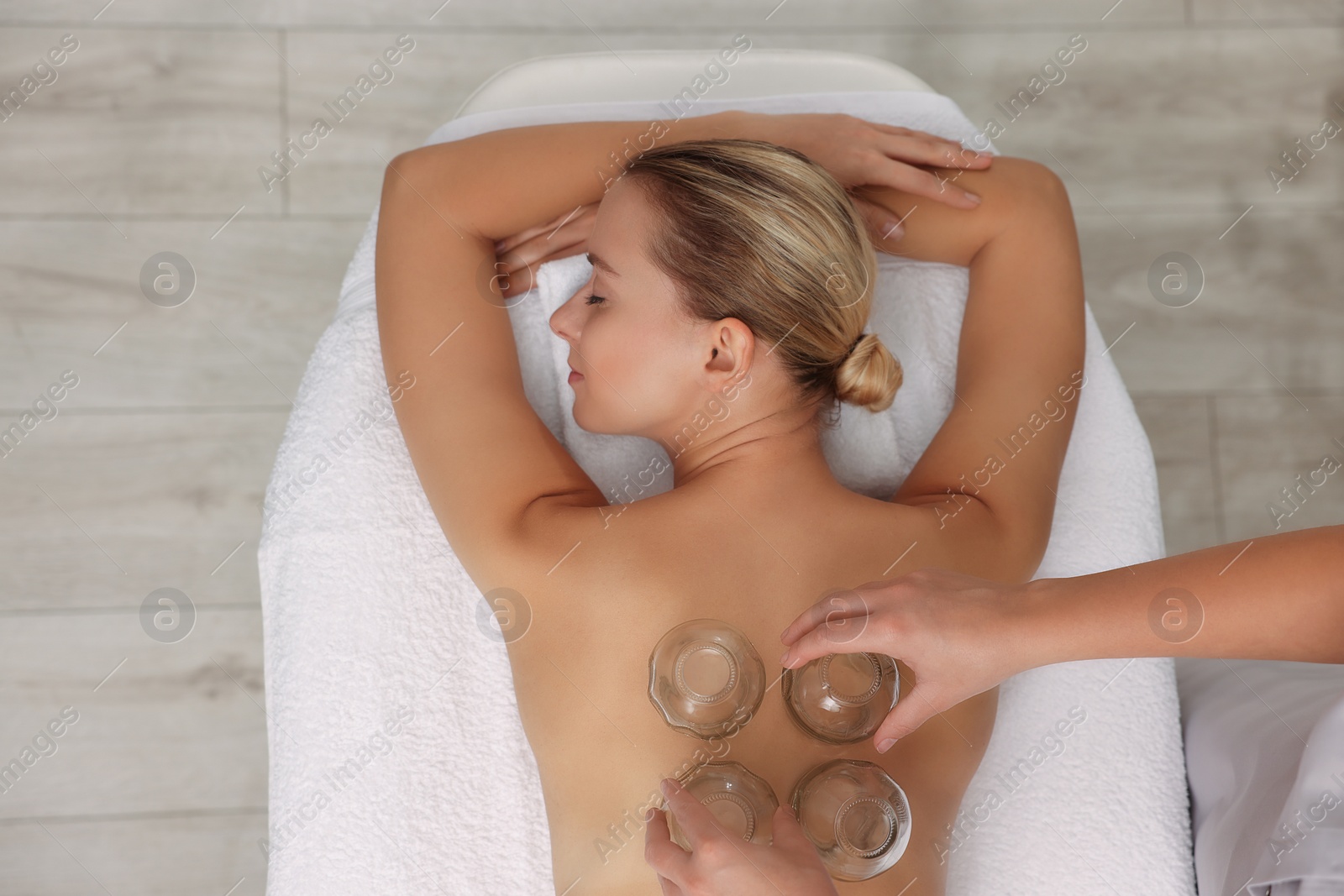 Photo of Therapist giving cupping treatment to patient indoors, top view