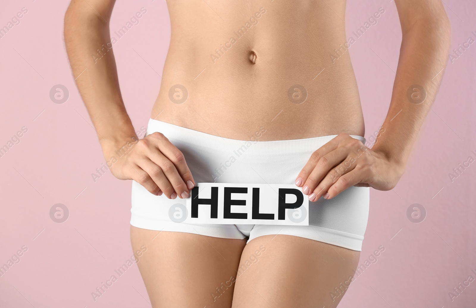 Photo of Young woman holding card with word HELP on color background. Gynecology concept