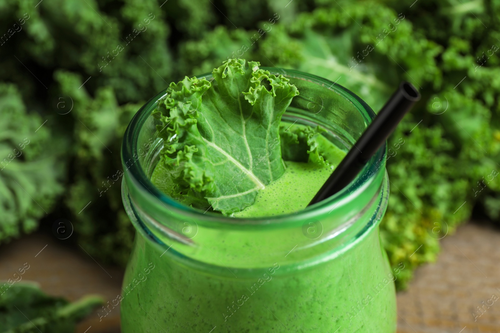 Photo of Tasty fresh kale smoothie on table, closeup