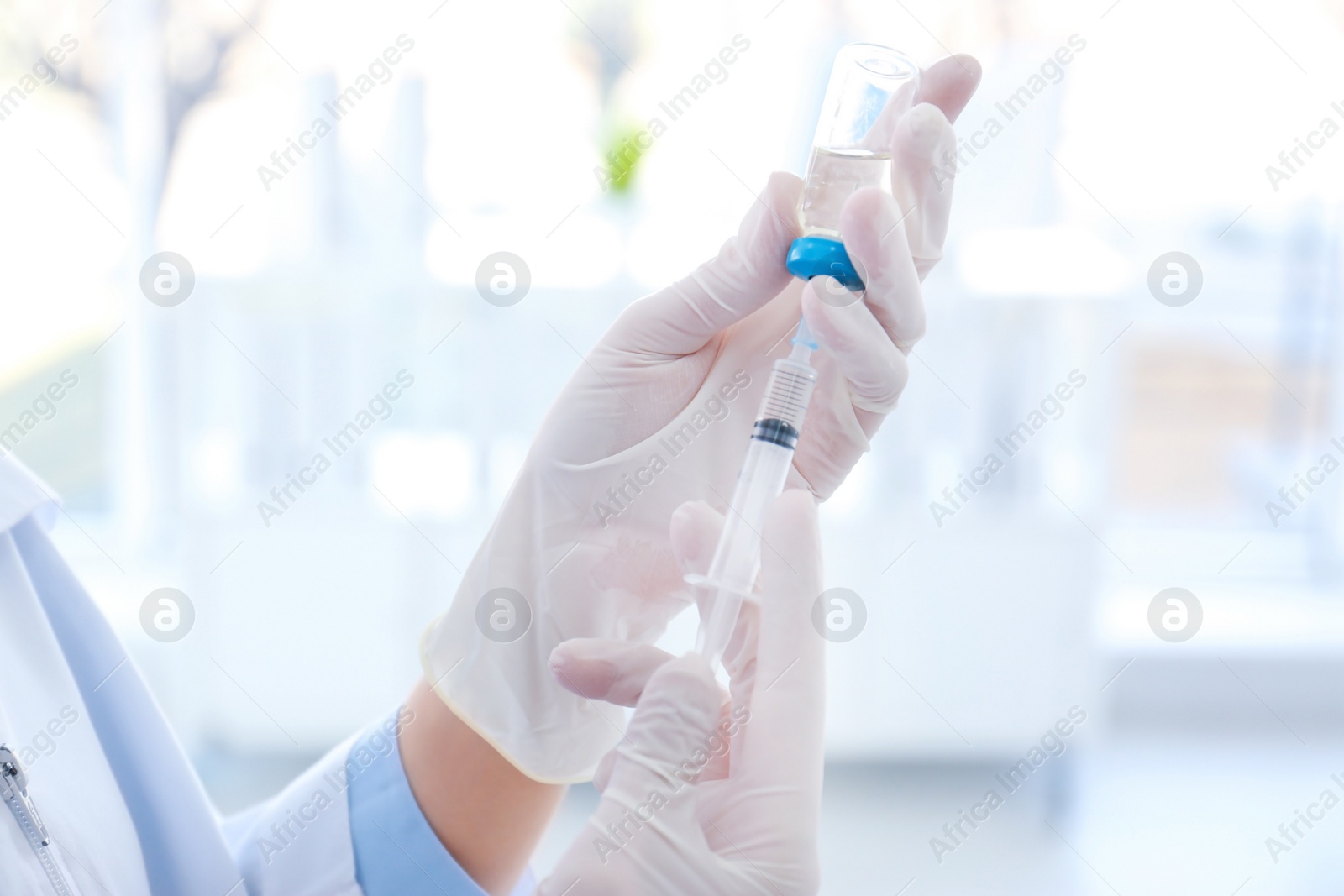 Photo of Female doctor with vial and syringe in hospital. Vaccination day