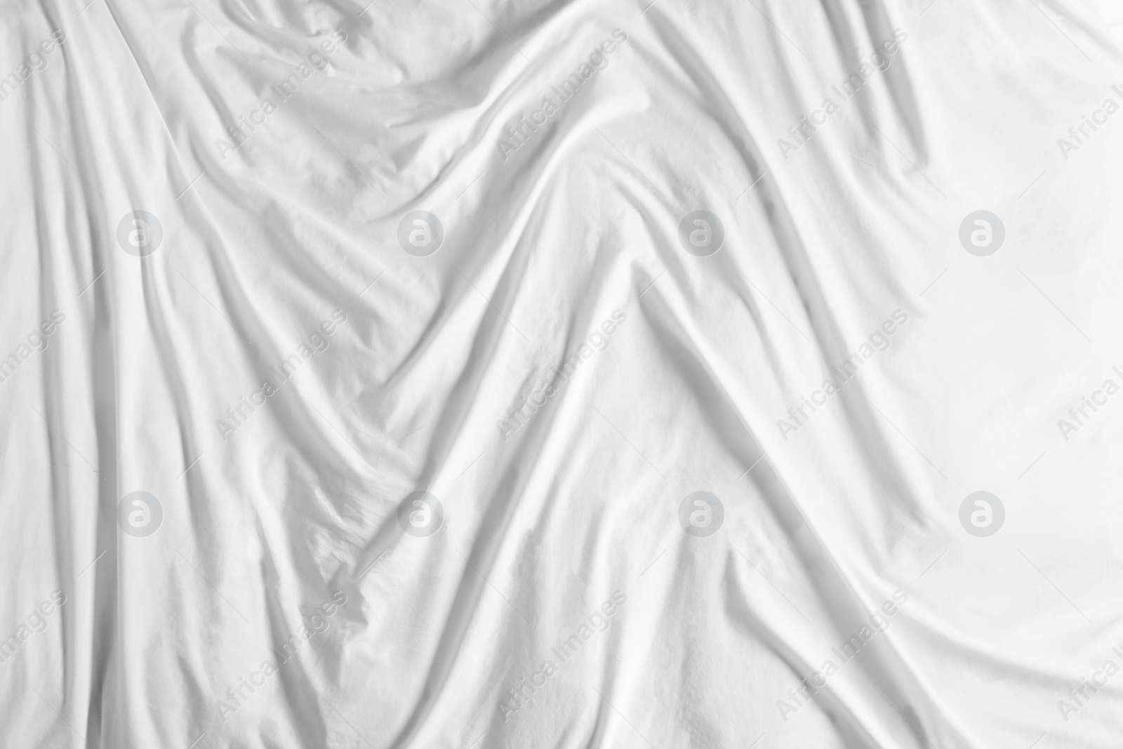 Photo of Crumpled white fabric as background, top view