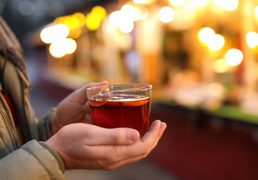 Man with mulled wine at winter fair, closeup
