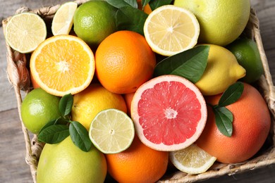 Different cut and whole citrus fruits on table, top view