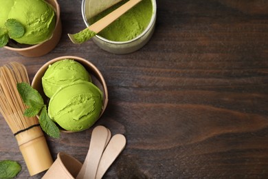 Photo of Flat lay composition with tasty matcha ice cream in paper cups on wooden table. Space for text