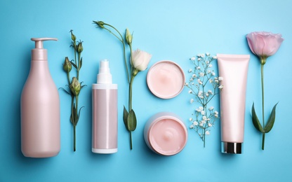 Photo of Flat lay composition with hair cosmetic products on light blue background