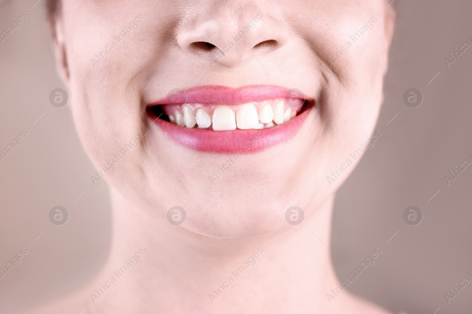 Photo of Young woman with healthy teeth smiling on color background, closeup