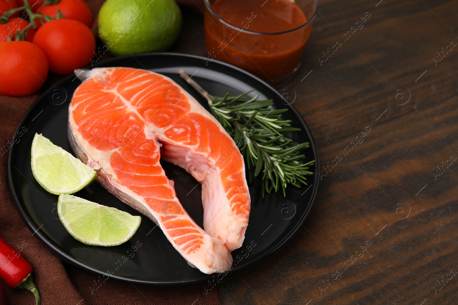 Photo of Fresh fish, products and marinade on wooden table, closeup. Space for text