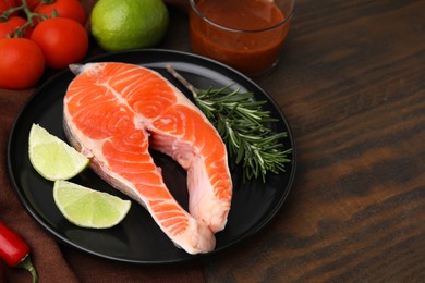 Photo of Fresh fish, products and marinade on wooden table, closeup. Space for text