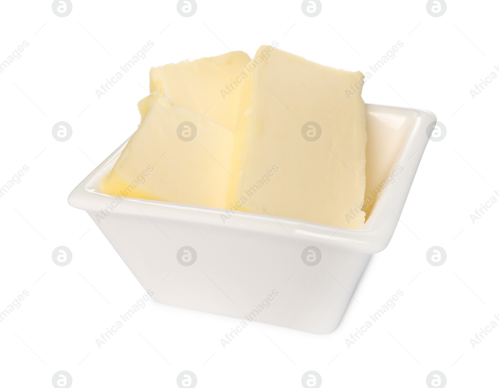 Photo of Tasty butter pieces in bowl isolated on white