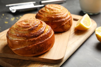 Photo of Wooden boards with tasty buns on table, closeup. Fresh from oven