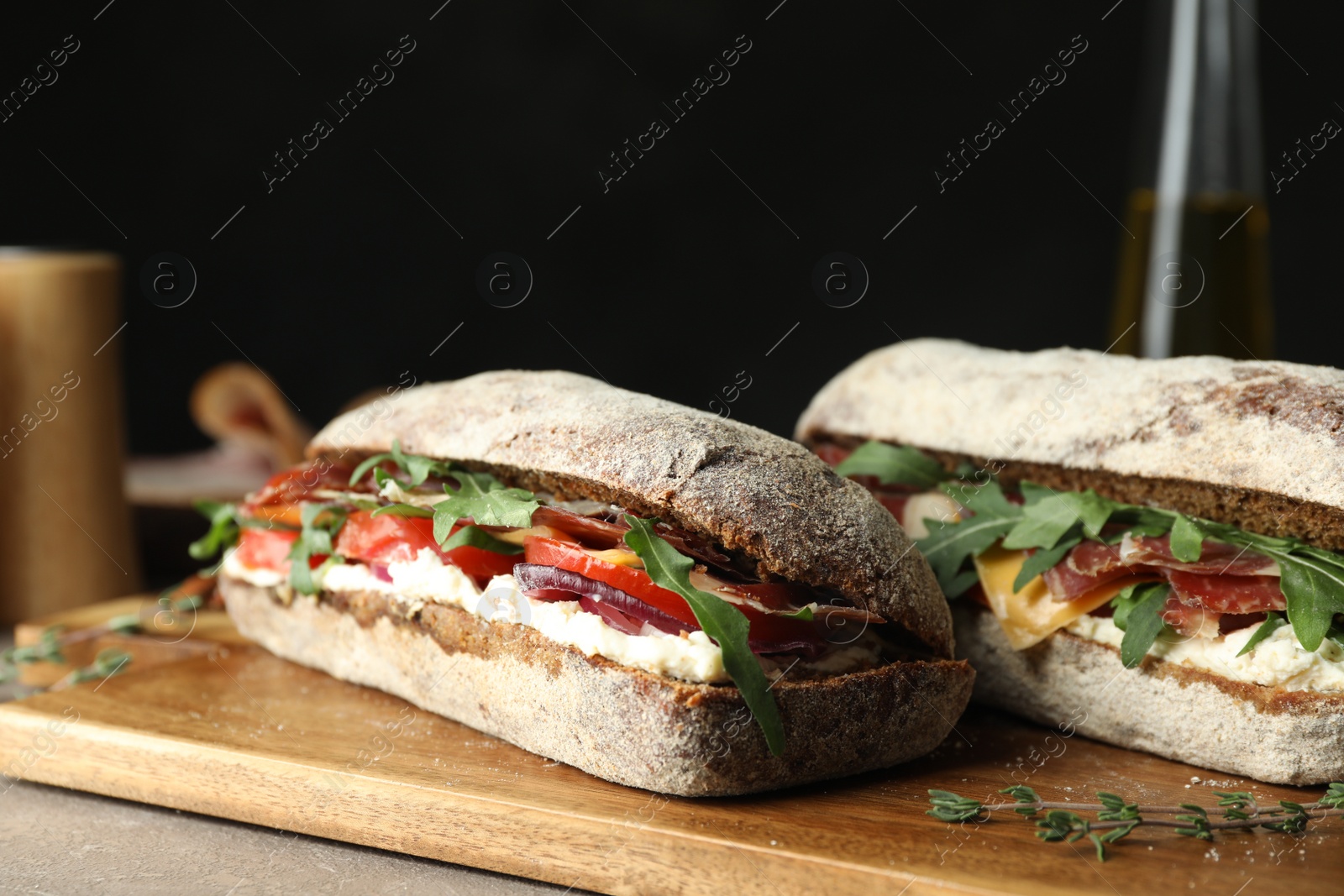 Photo of Delicious sandwiches with fresh vegetables and prosciutto on table