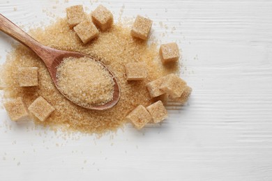 Different types of brown sugar on white wooden table, top view. Space for text