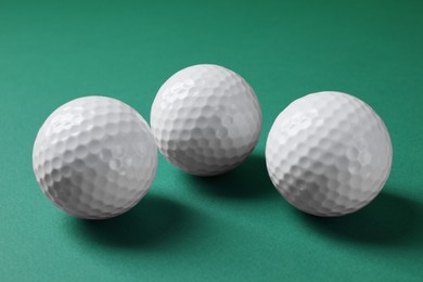 Photo of Three golf balls on green background, closeup
