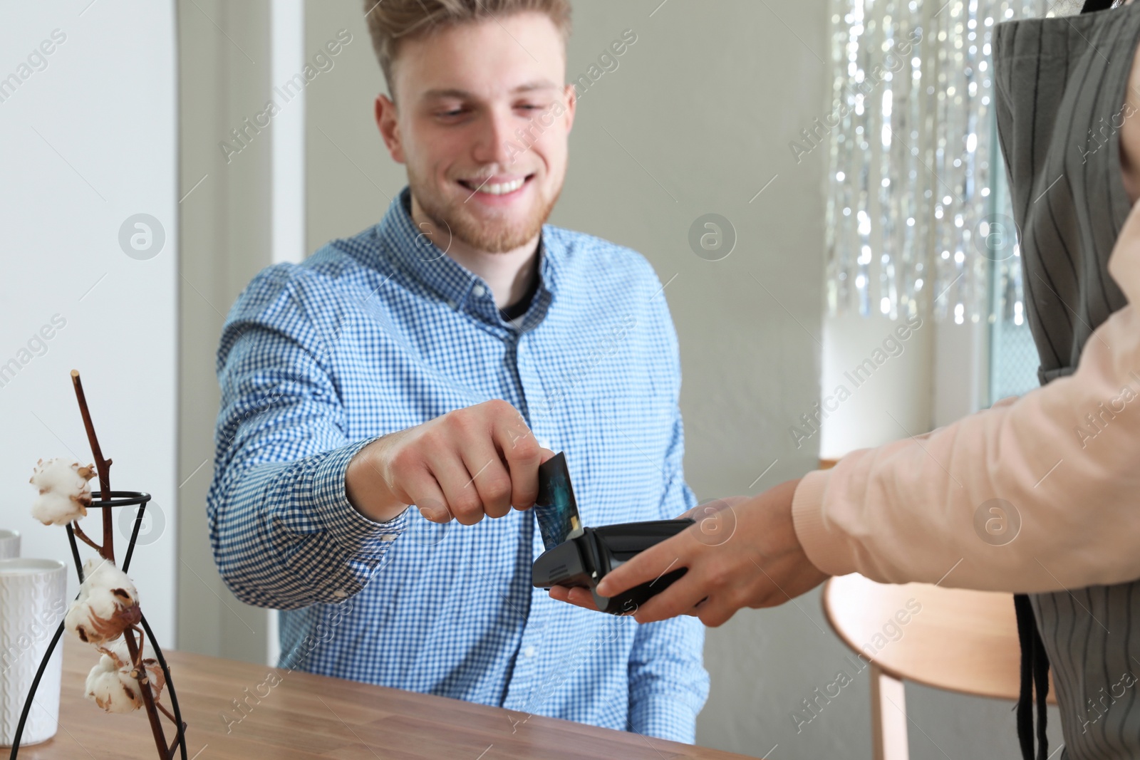 Photo of Client using credit card machine for non cash payment in cafe