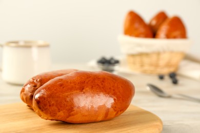 Delicious baked pirozhki on white table, closeup. Space for text