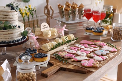 Photo of Baby shower party. Different delicious treats on wooden table indoors