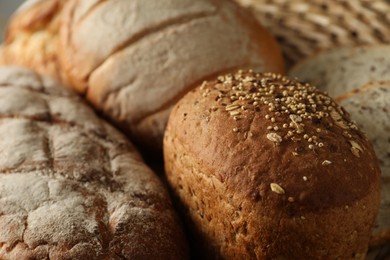 Photo of Basket with different types of fresh bread on table, closeup