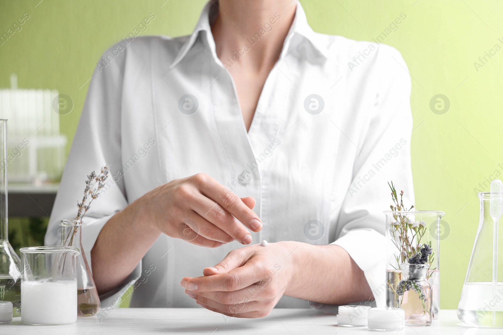 Photo of Scientist testing developed cosmetic product in laboratory, closeup