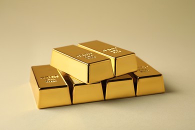 Many shiny gold bars on beige background