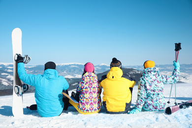 Photo of Group of friends with equipment at ski resort, back view. Winter vacation