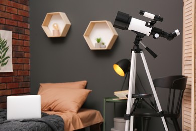 Tripod with modern telescope in stylish room. Space for text