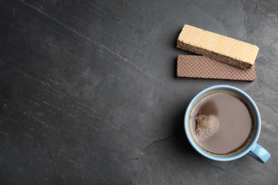 Breakfast with delicious wafers and cup of coffee on grey table, flat lay. SPace for text