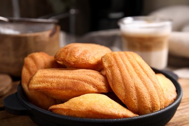 Photo of Delicious madeleine cakes in frying pan on table, closeup