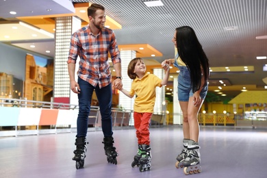 Happy family spending time at roller skating rink